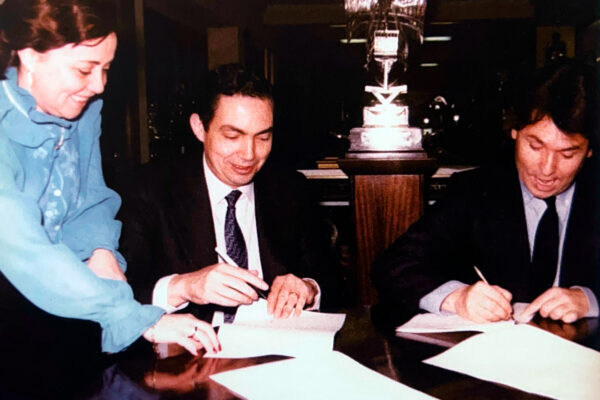 Raphael firma el contrato para el concierto en el Bernabeu, junto a un representante del Real Madrid.